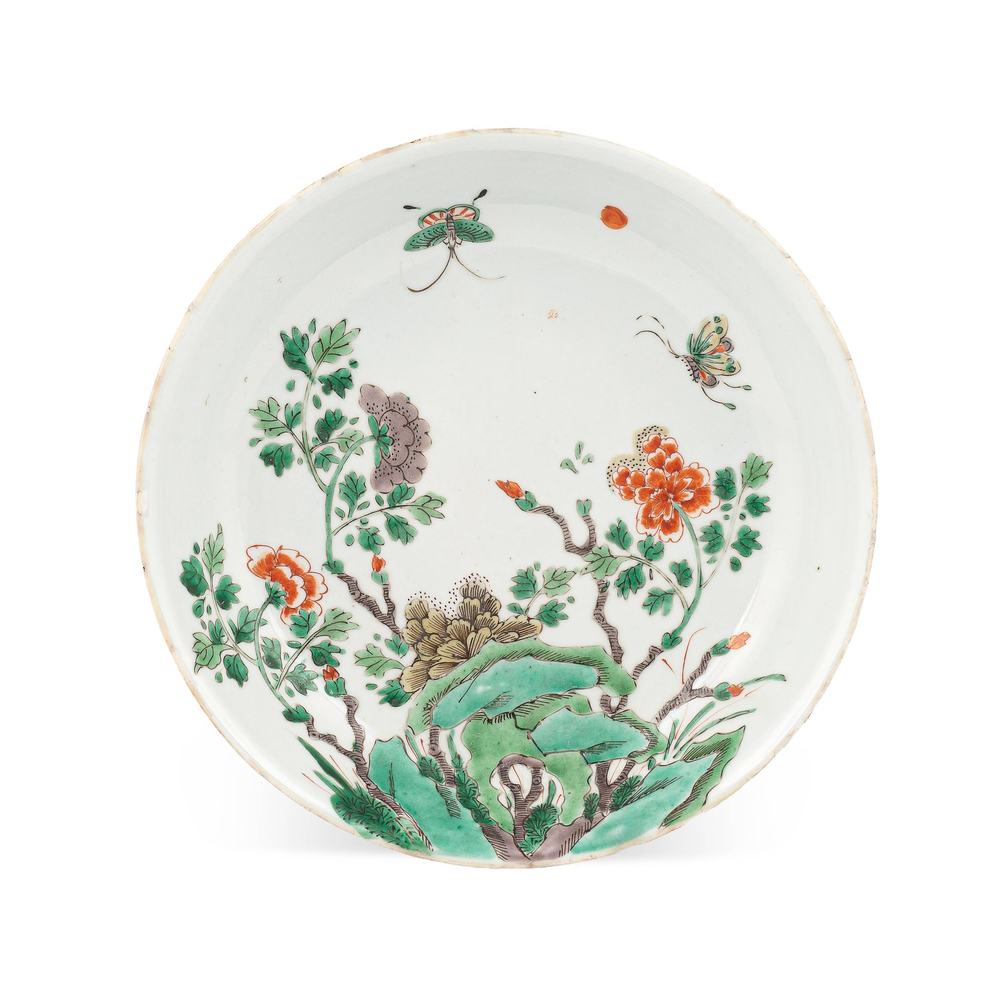 AA84 A Chinese famille verte circular dish, Qing dynasty, Kangxi period, painted with butterflies and peony among garden rocks, 21cm diameter