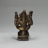 X931 Indian miniature bronze of a seated four armed figure; height:2